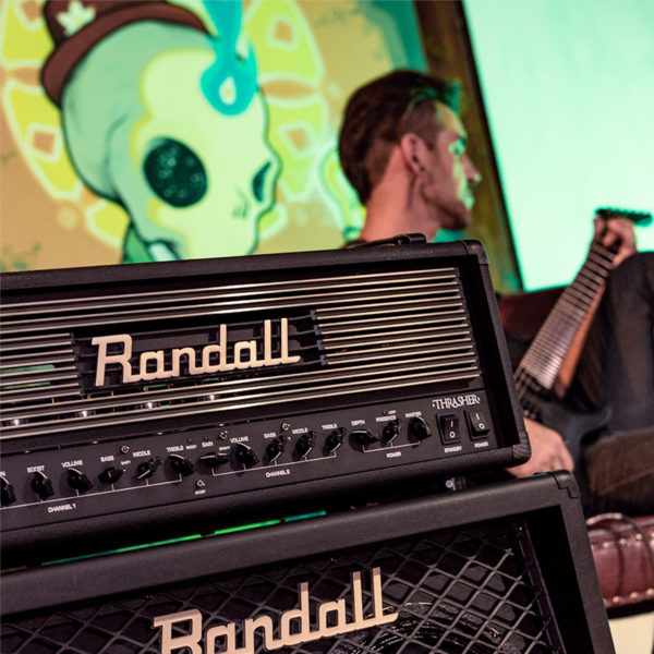 Randall cabinet and Thrasher Tube Amplifier with man playing electric guitar in background